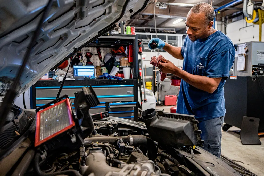 Mechanic checking the oil level in an engine bay